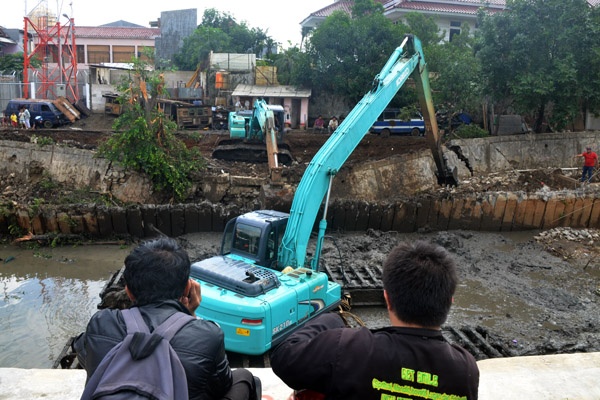 Pekerja Perbaiki Tanggul Jebol di Jalan Talang